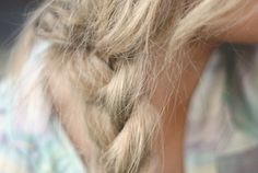 a close up of a woman's hair with braids on her head and an apple in the background