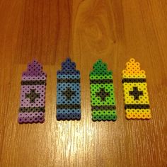 four pieces of perler bead sitting on top of a wooden table