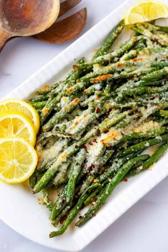 asparagus with lemon and parmesan cheese on a white plate