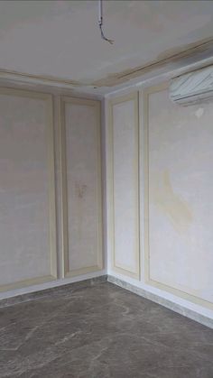 an empty room with white walls and beige paneling on the walls is being painted