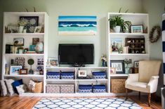 a living room filled with furniture and a flat screen tv on top of a wooden shelf