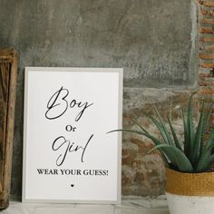 a sign that says boy or girl wear your guess next to a potted plant