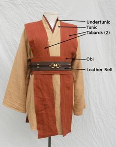 the parts of a costume on a mannequin's head, including an orange robe and brown belt