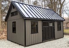 a small shed with a metal roof and windows