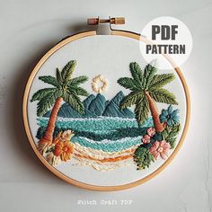 an embroidered tropical scene with palm trees and waves