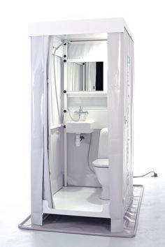 a white toilet sitting next to a sink in a small bathroom with a shower curtain