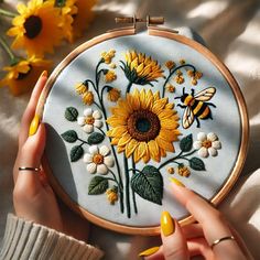 🎀 🎈🎀  DOWNLOAD THE  WHOLE SHOP PATTERNS - CRAZY PRICE RIGHT NOW 🎀  🎈  🎀  CHECK HERE 👉 https://www.etsy.com/ca/listing/1787068164/ This stunning embroidery hoop features an intricate design of golden sunflowers, delicate white daisies, lush green foliage, and a charming bee, all set against a soothing soft blue fabric. The artistry captures the beauty of nature with vibrant colors and textured stitching, making it a perfect piece to inspire creativity or adorn any space. The natural lighting enhances the embroidery's depth and detail, while the blurred background subtly focuses attention on the centerpiece. This piece reflects the timeless elegance of handmade embroidery and the personal touch of an artist's hands. It's ideal for showcasing the beauty of handcrafts, whether as a gift Embroidery Designs Sunflower, Embroidered Sunflowers, Sunflower Daisy, Daisy Embroidery, White Daisies, Handmade Embroidery, Embroidery Hoop Art, Blurred Background, Hoop Art