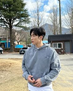 a young man standing in the middle of a parking lot