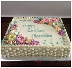 a birthday cake with white frosting and flowers on it