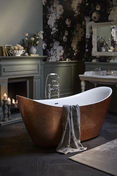 a bathtub with a towel draped around it in front of a fireplace and candles