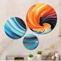 three circular paintings on a wall in a living room with a fireplace and vases