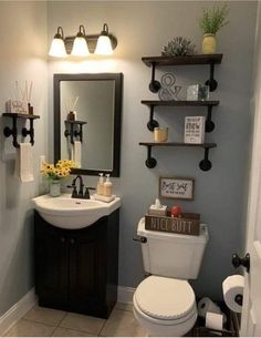 a bathroom with a toilet, sink and shelves on the wall in it's corner