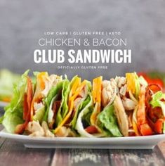 a chicken and bacon club sandwich on a white plate with lettuce, tomato, and cheese