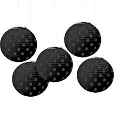 four black paper lanterns hanging from strings on a white background with polka dot design in the middle