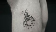 a small black and white tattoo of a bee