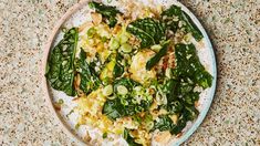 a white plate topped with green vegetables and rice