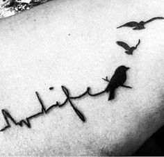 a black and white photo of a bird with heartbeat tattoo on it's arm