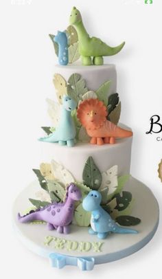 a three tiered cake decorated with dinosaurs and leaves is featured in this advertisement for baby's first birthday