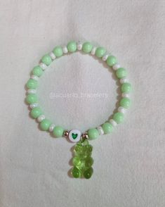 a bracelet with a green teddy bear charm