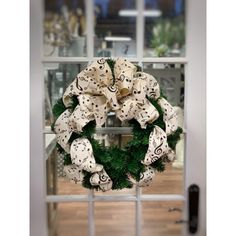 a wreath with musical notes on it sitting in front of a glass door that is open