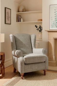 a living room with a chair and fireplace