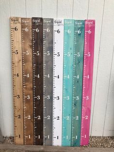 several rulers are lined up against a white wall