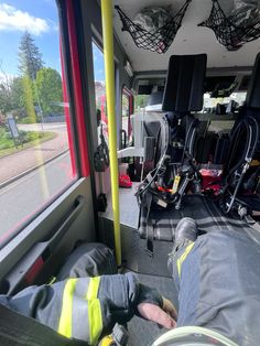 the inside of a bus with its door open and feet propped up on the seat