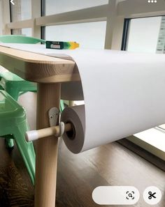 a close up of a white roll of paper on a table with a green chair