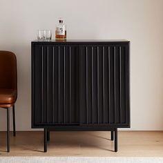 a black cabinet sitting next to a brown chair