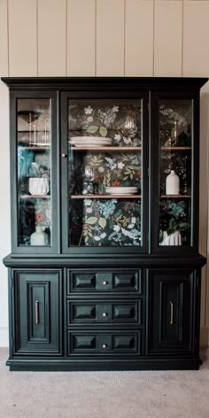 a black china cabinet with glass doors and drawers