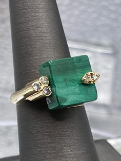 This is a very unique and beautiful ring.  It was designed and made in 14 karat solid yellow gold. Set in the top center of the ring is a square green malachite stone. There are diamonds set on top of the stone, while the other side of the ring offers a triple tubular design with diamonds set in each tube. A fun ring while still being classy and different.  It looks gorgeous on a woman's hand! Weight-8.2 grams Size-7 TDW:0.25cts Our Price $695.00 Please See Our Video Remember - If you're purchasing for yourself or a gift for a loved one, buy with confidence.  We Guarantee Everything We Sell!  SKU # R698 Square Stone Ring Designs, Square Stone Ring, Gold Coin Jewelry, Stone Ring Design, Black Pearl Bracelet, Amethyst Bangle, Malachite Ring, Malachite Rings, Square Stone