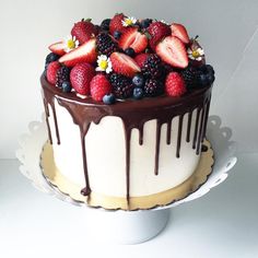 a cake with chocolate icing and fresh berries on top