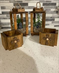 three wooden boxes with plants in them sitting on a counter next to a brick wall