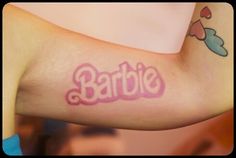 a close up of a person's arm with a tattoo that says barbie on it