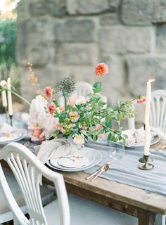 a table set with flowers and candles on it