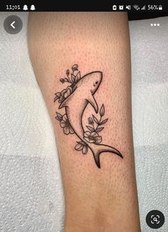 a shark with flowers on it's leg is seen in this tattoo photo taken by the