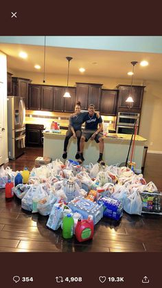 two people sitting on top of bags in a kitchen