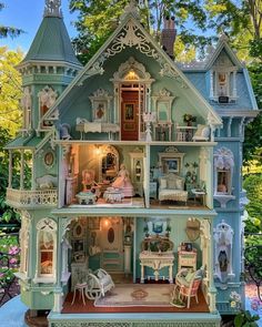 a doll house is shown with furniture and accessories in the front yard, surrounded by trees