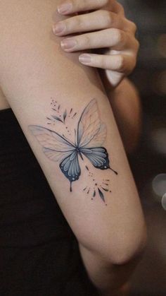 a woman with a butterfly tattoo on her arm