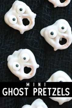 white ghost pretzels with googly eyes on black background for halloween party decoration