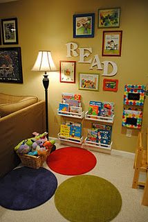 a child's playroom with toys and books on the floor in front of a bed