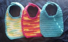 three crocheted purses sitting on top of a bed