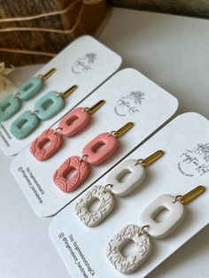 four pairs of earrings are displayed on a card