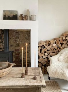 a living room filled with furniture and a fire place next to a pile of logs