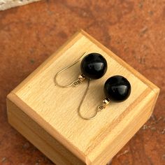 14KT yellow gold ear wire earrings with genuine black onyx ball/bead. Earrings measure: 22mm (length) x 11.50 (width) Hoops weight: 3 grams Stamped on wire Black Drop Earrings With French Hook, Black Beaded Round Earrings, Adjustable Black Jewelry With Ear Wire, Black Adjustable Jewelry With Ear Wire, Elegant Black Round Bead Earrings, Classic Onyx Dangle Jewelry, Classic Black Dangle Jewelry, Black Hypoallergenic Round Beads Jewelry, Elegant Black French Hook Earrings