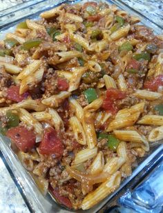 a glass casserole dish filled with pasta, meat and veggie toppings