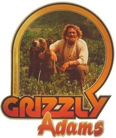 a man kneeling next to a brown bear on top of a grass covered field with the words grizzly adams