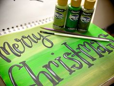 three bottles of alcohol sitting on top of a spiral bound notebook with markers and pencils