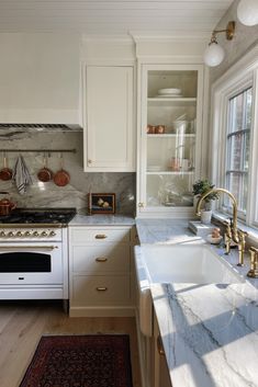 a kitchen with marble counter tops and white cabinets