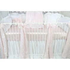 a white crib with pink and white bedding